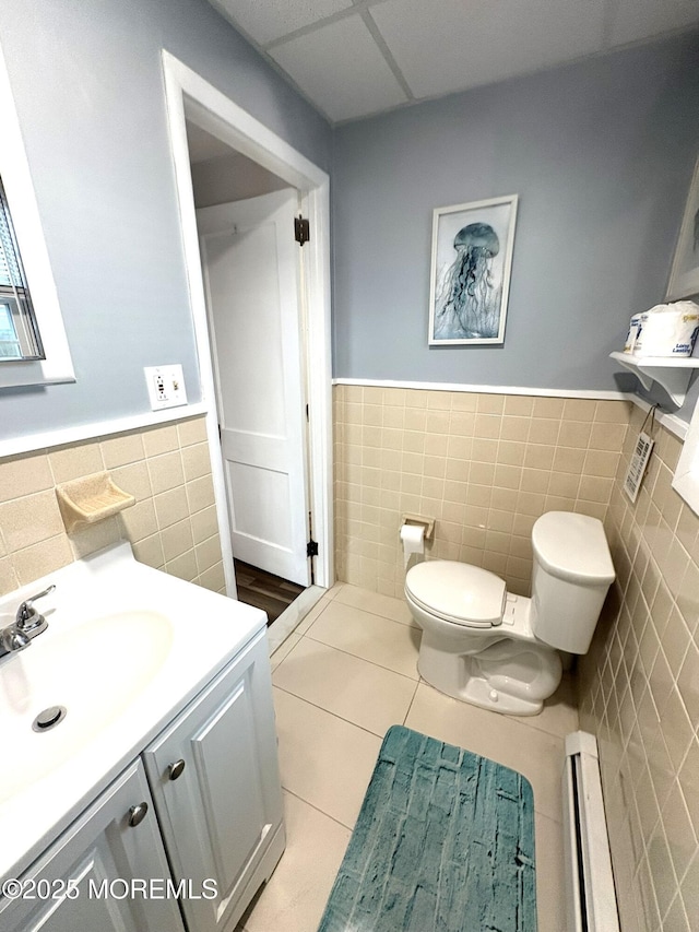 25 O St, Seaside Park, NJ 08752 - half bath with tile walls, wainscoting, a baseboard heating unit, vanity, and tile patterned floors