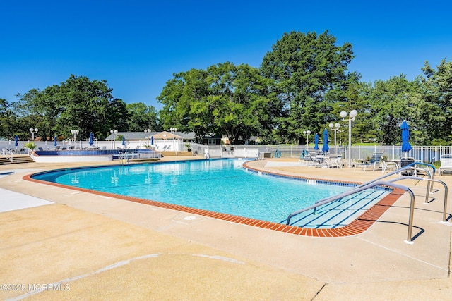 community pool featuring a patio and fence