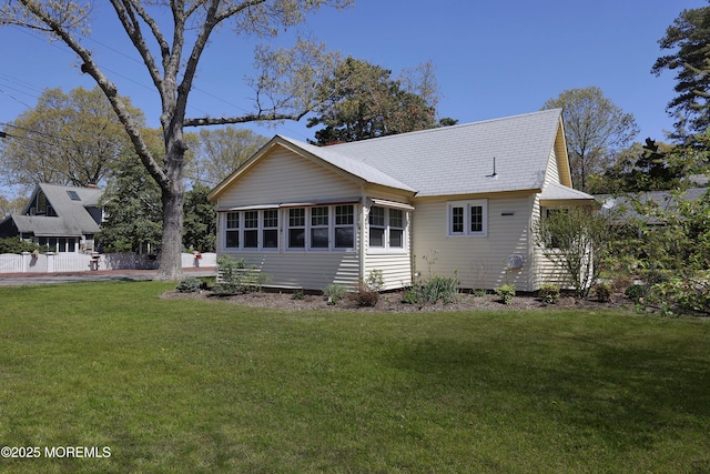 rear view of house featuring a yard