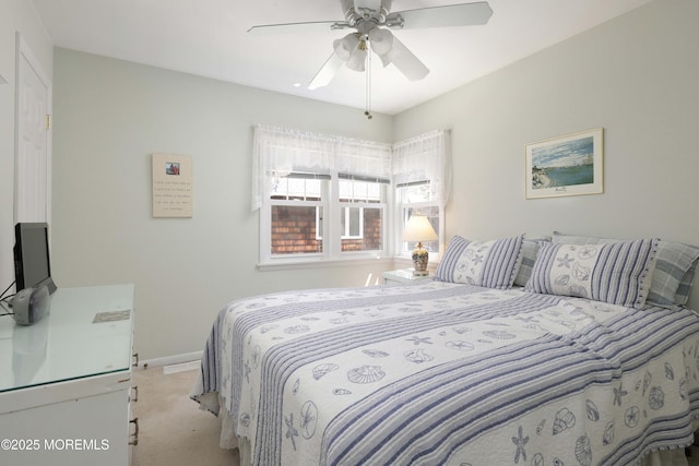 bedroom with a ceiling fan, baseboards, and light colored carpet