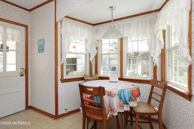 dining area with crown molding, plenty of natural light, and wallpapered walls