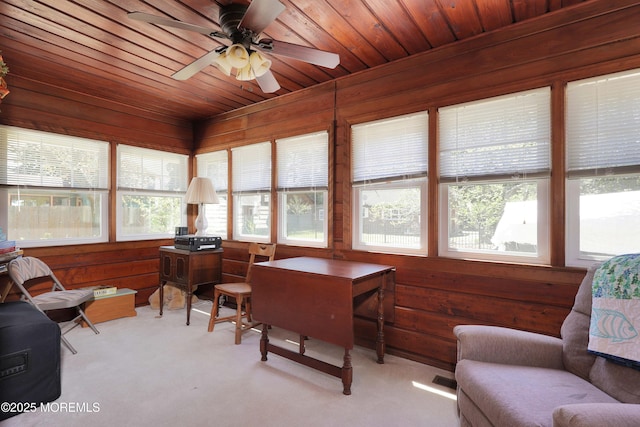 sunroom with wooden walls, wood ceiling, and carpet