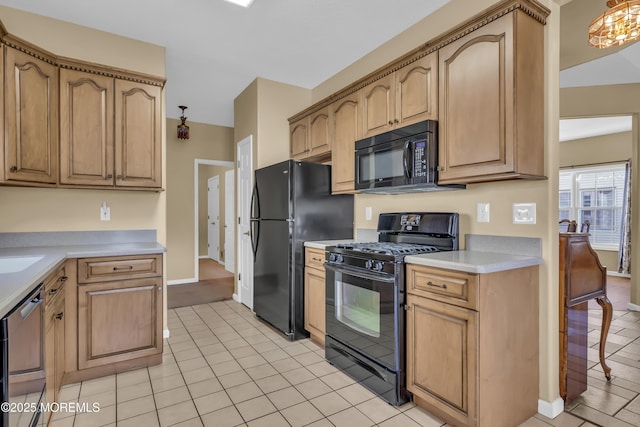kitchen featuring light tile patterned floors, baseboards, black appliances, and light countertops
