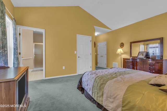 bedroom with visible vents, baseboards, lofted ceiling, carpet, and ensuite bath
