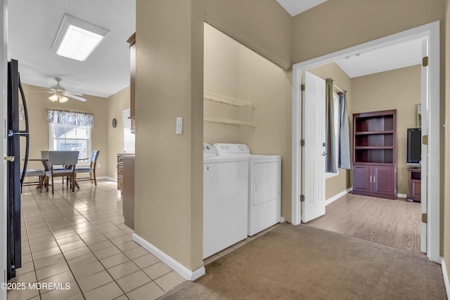 washroom with baseboards, ceiling fan, light carpet, and washing machine and clothes dryer