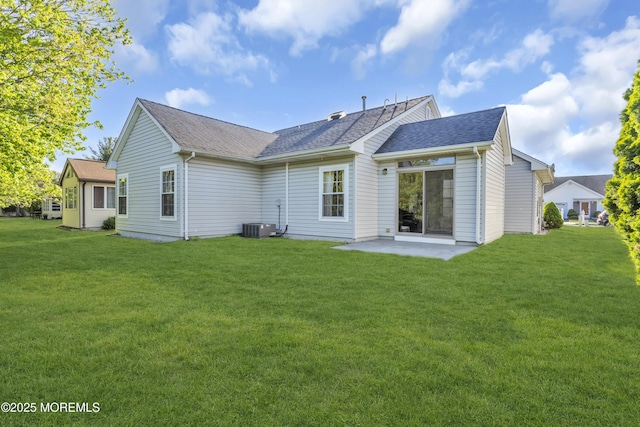 back of property with a lawn, a patio, and roof with shingles