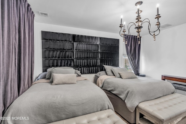 bedroom with visible vents and a notable chandelier
