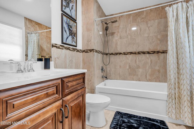 bathroom with vanity, shower / tub combo with curtain, toilet, tile walls, and tile patterned floors