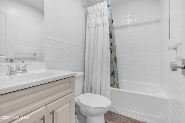 full bath featuring toilet, wood finished floors, shower / tub combo, and vanity