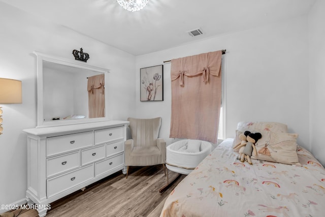 bedroom featuring visible vents and wood finished floors