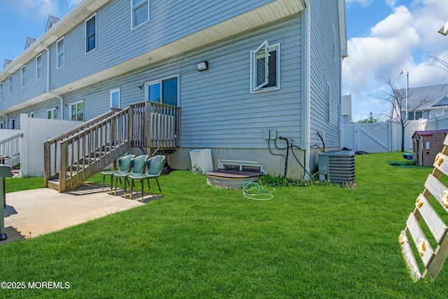 back of property with a fenced backyard, a patio, a lawn, and central AC