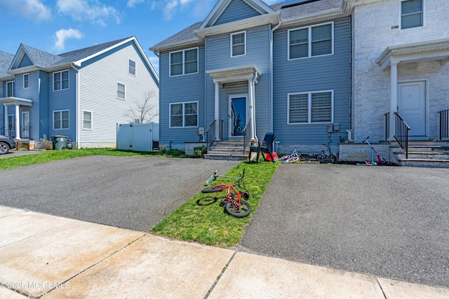 townhome / multi-family property with driveway and entry steps