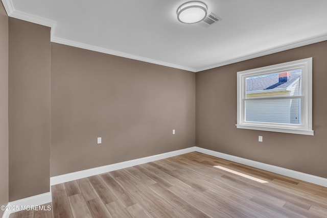 unfurnished room featuring crown molding, visible vents, and light wood finished floors