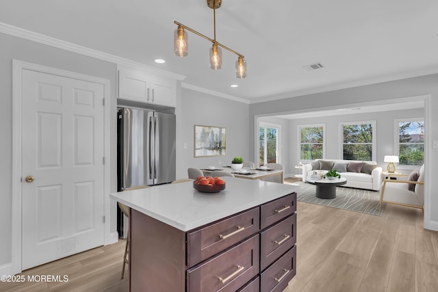 kitchen featuring light wood-style floors, freestanding refrigerator, white cabinetry, open floor plan, and visible vents