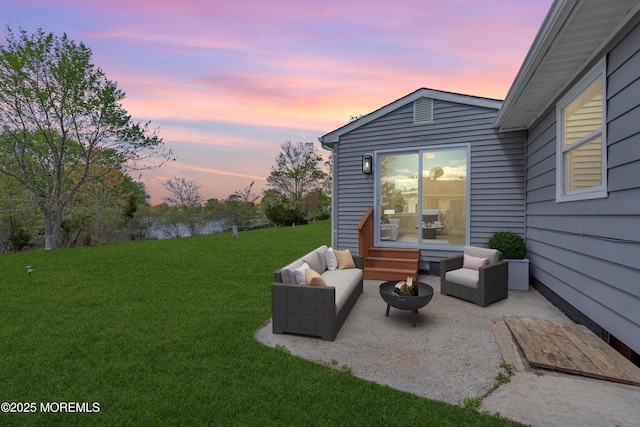 patio terrace at dusk featuring a yard and an outdoor living space with a fire pit