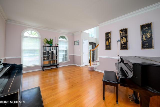 sitting room with stairs, baseboards, ornamental molding, and light wood finished floors