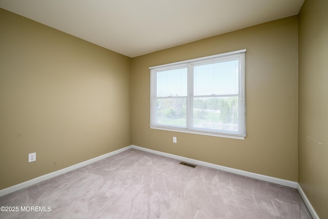 unfurnished room featuring visible vents, baseboards, and light carpet