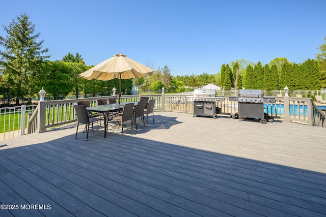 deck with area for grilling, fence, a fenced in pool, and outdoor dining area
