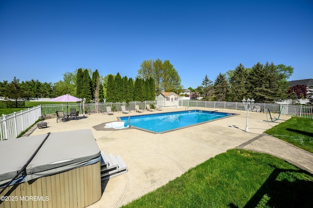 view of swimming pool featuring a hot tub, a fenced backyard, a fenced in pool, an outbuilding, and a patio area