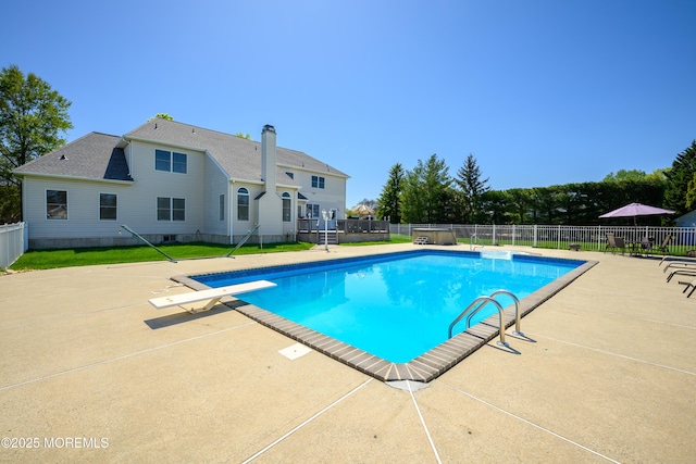 view of pool with a fenced in pool, a diving board, a patio area, and fence