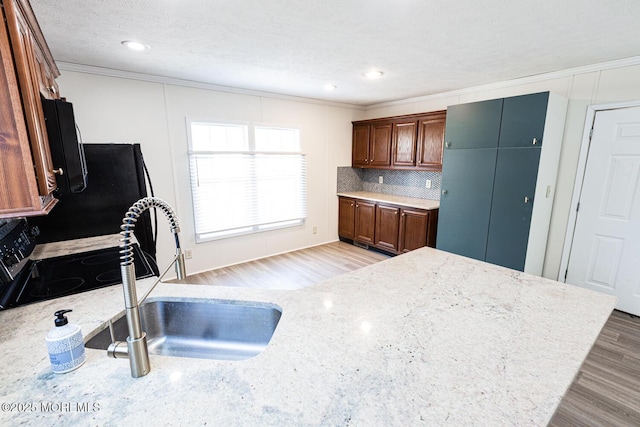 89 Woodchuck Pkwy, Whiting, NJ 08759 - kitchen with crown molding, decorative backsplash, range with electric stovetop, a sink, and light wood finished floors