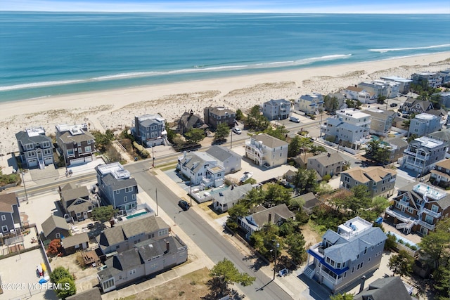 drone / aerial view featuring a beach view and a water view