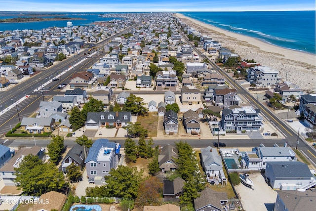 bird's eye view featuring a water view, a view of the beach, and a residential view