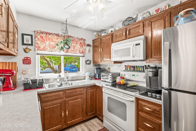 435B New Castle Ct, Manchester, NJ 08759 - kitchen with brown cabinetry, a sink, white appliances, and light countertops