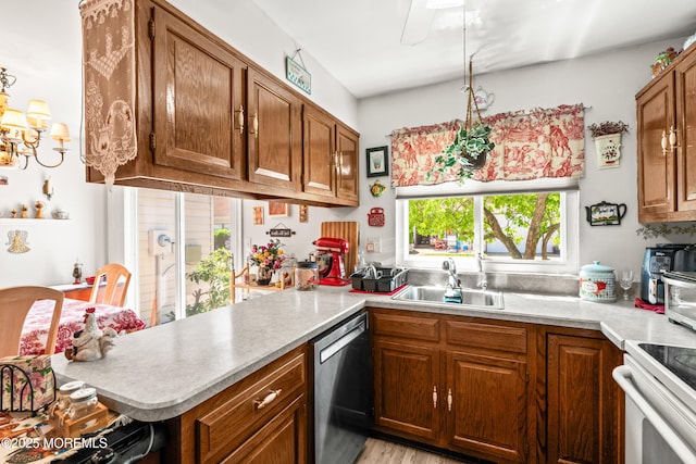 435B New Castle Ct, Manchester, NJ 08759 - kitchen featuring a peninsula, light countertops, brown cabinets, a sink, and dishwasher