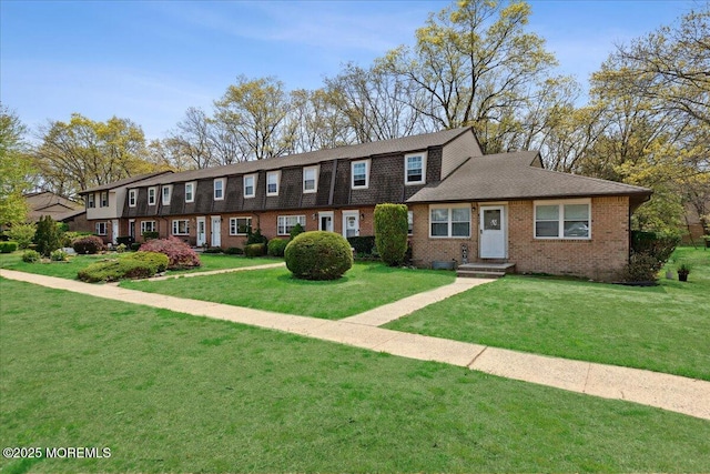 view of front of house with a front lawn and brick siding