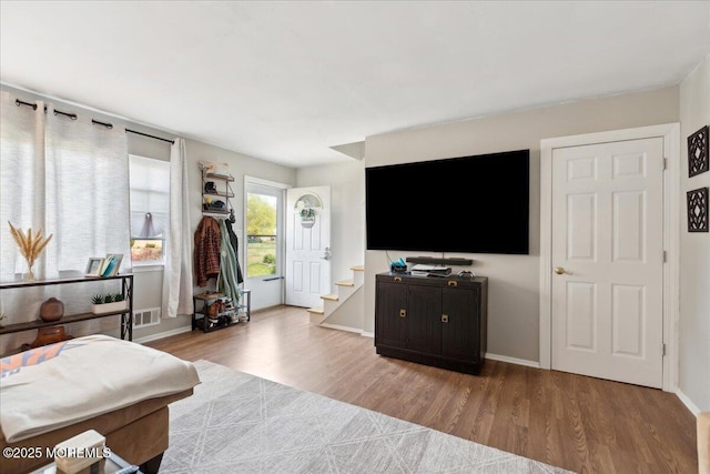 bedroom with baseboards, wood finished floors, and visible vents