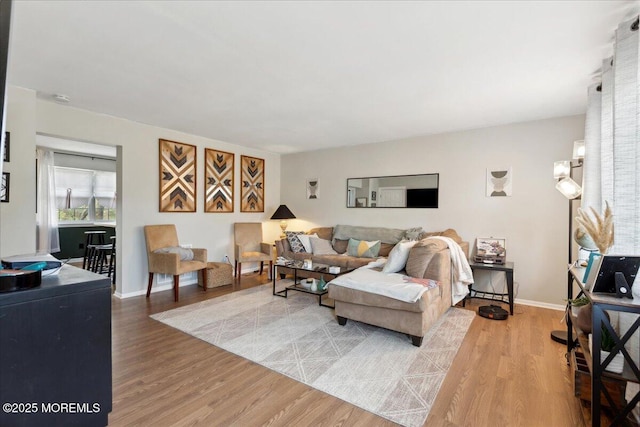 living area featuring baseboards and light wood-style floors