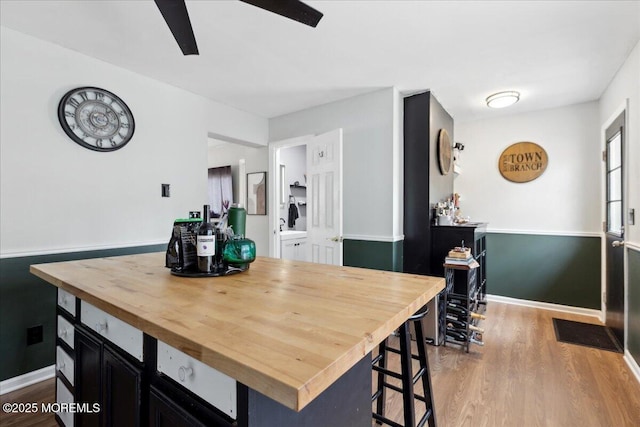 dining room with a ceiling fan, baseboards, and wood finished floors