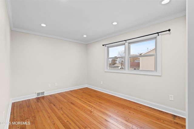 spare room featuring crown molding, baseboards, and visible vents
