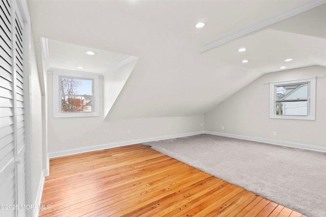 bonus room featuring baseboards, recessed lighting, light wood finished floors, and a wealth of natural light