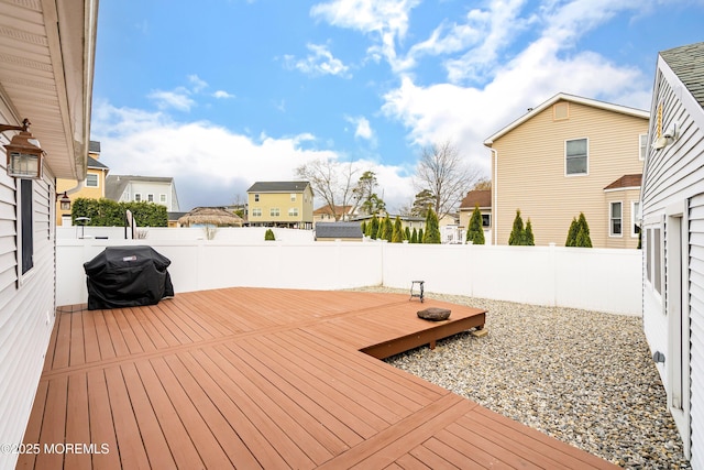 deck featuring a residential view, a fenced backyard, and a grill