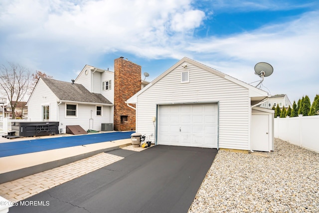 exterior space with fence, central AC, and aphalt driveway