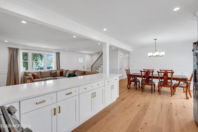 kitchen with white cabinetry, light countertops, recessed lighting, light wood finished floors, and pendant lighting