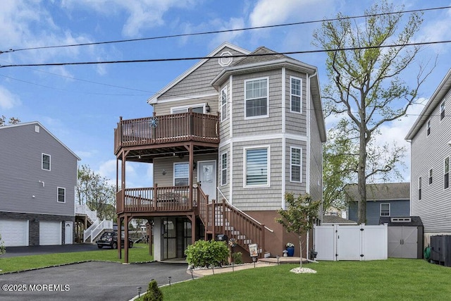 view of front of house with a garage, stairway, a front yard, a gate, and central air condition unit