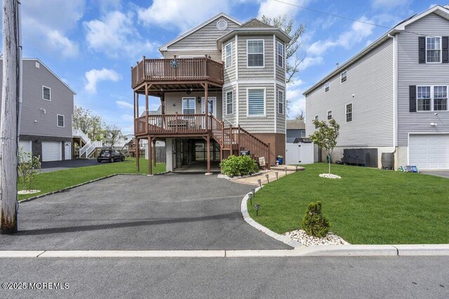 view of front of home with stairway, a garage, a front yard, and aphalt driveway