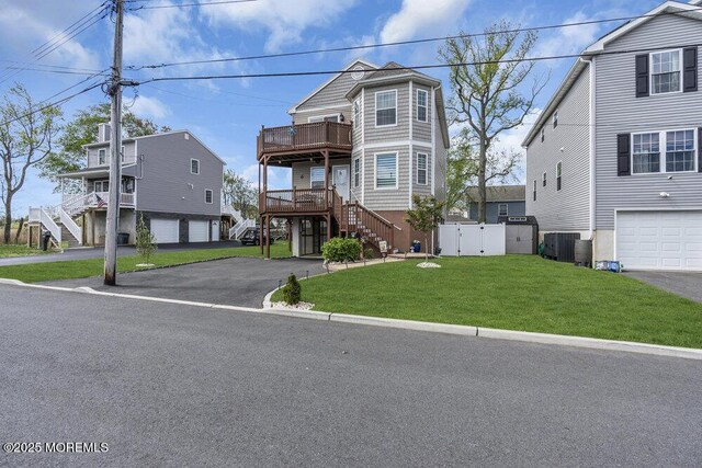 view of front of property with fence, stairs, a front yard, and aphalt driveway