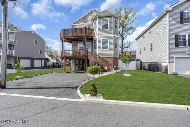 view of front of house with stairway, an attached garage, driveway, and a front lawn