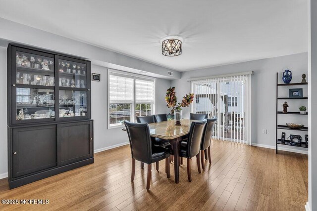 dining space featuring baseboards and wood finished floors