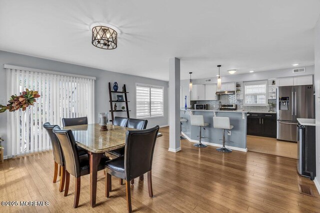 dining room with visible vents, a wealth of natural light, and light wood-type flooring