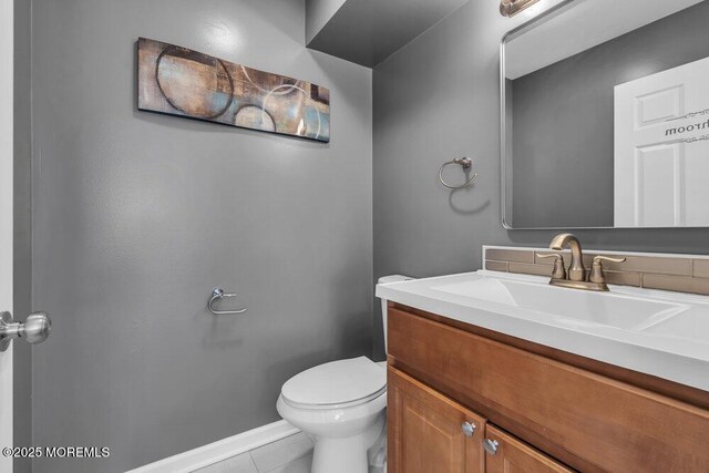 bathroom featuring toilet, baseboards, tile patterned flooring, and vanity