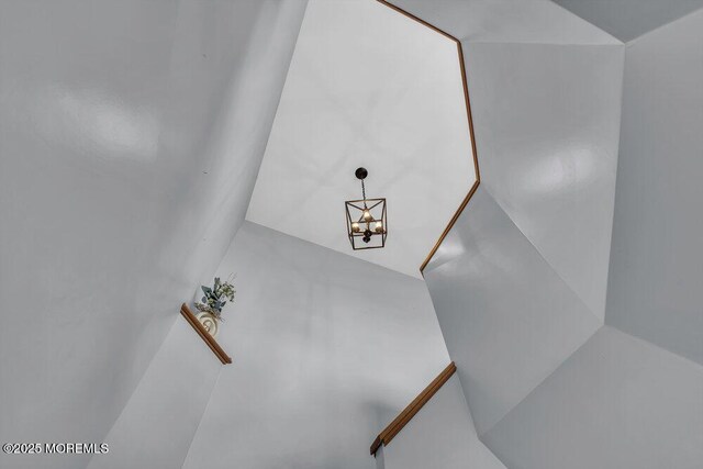 stairway featuring a notable chandelier
