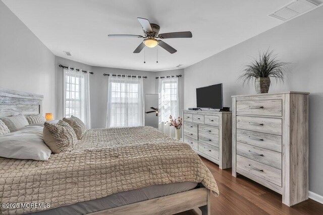 bedroom featuring a ceiling fan, dark wood-style flooring, and visible vents