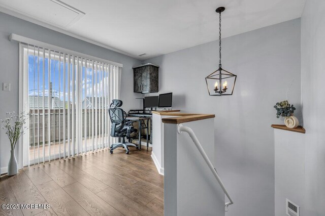 office with baseboards, visible vents, wood finished floors, and an inviting chandelier