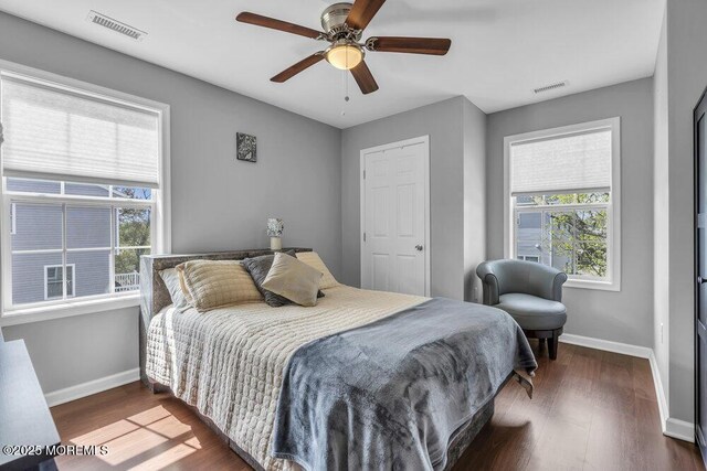 bedroom with baseboards, visible vents, and multiple windows
