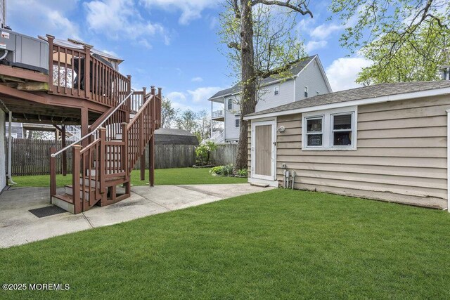 view of yard with a fenced backyard, a patio area, an outbuilding, and a deck